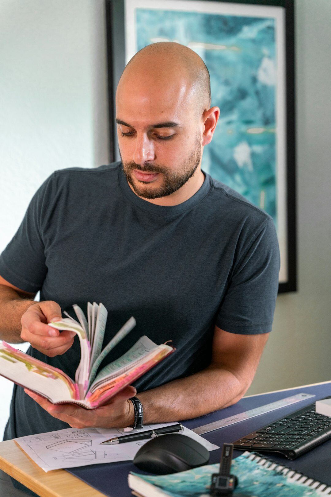 Man with short beard writing notes at a desk